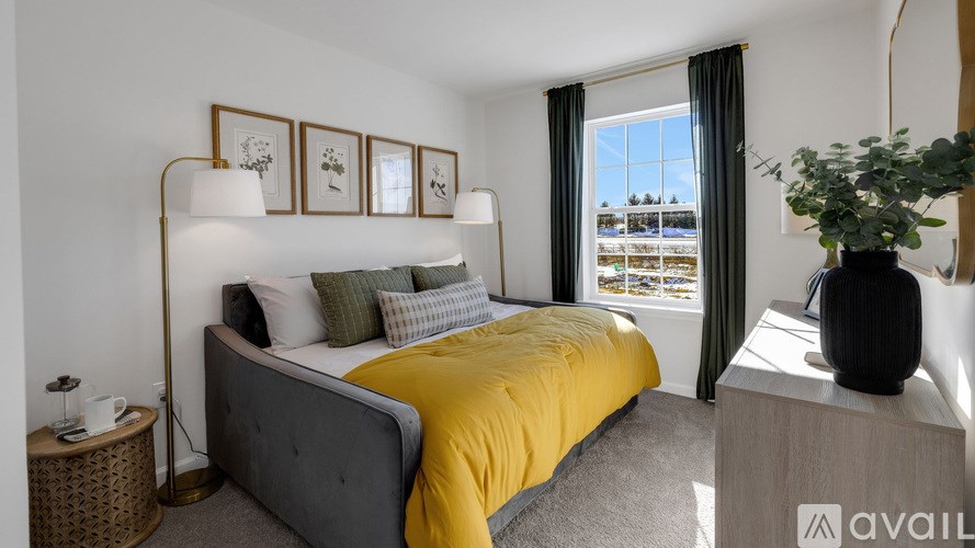 A bedroom with a bed, nightstand, and a window with a view of a snowy landscape.