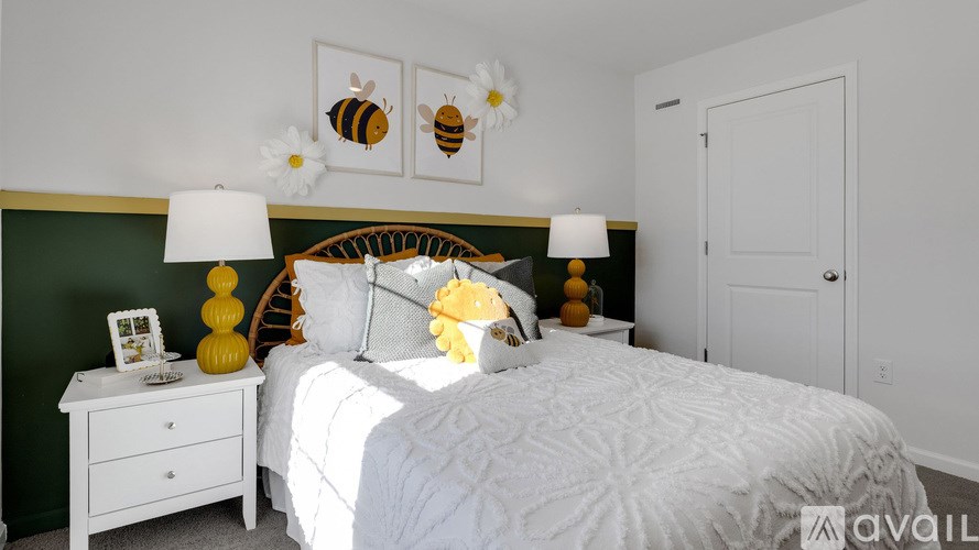 A bedroom with a white bed, a white nightstand, and a green headboard.