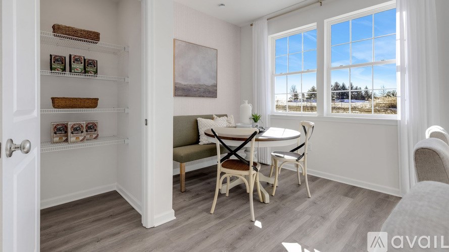 A dining room with a table set for two and a view of the outside through the window.