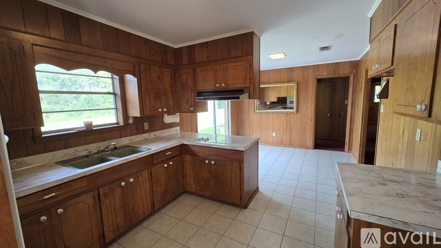 A kitchen with wooden cabinets and a marble countertop.