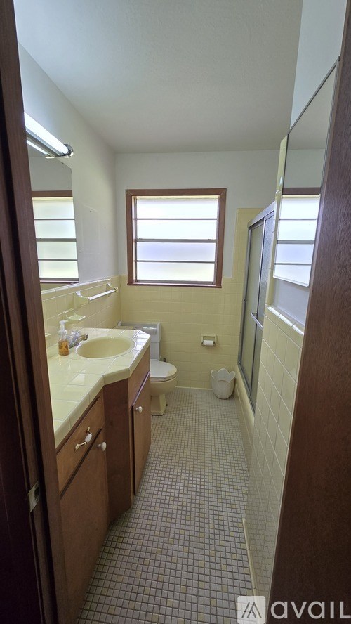 A bathroom with a toilet, sink, and shower.