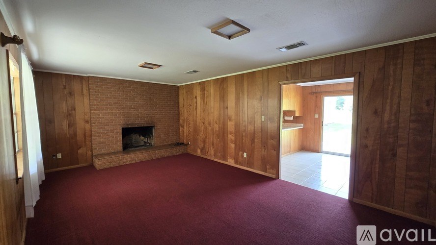 A room with a fireplace and wooden walls.