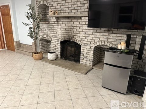 A living room with a fireplace and a television mounted above it.