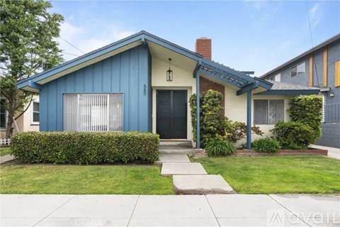 A blue house with a black door and a small porch.
