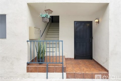 A black door is on the right side of a white wall.