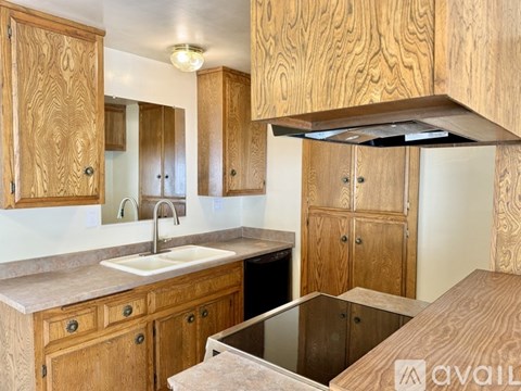 A kitchen with wooden cabinets and a stove top oven.