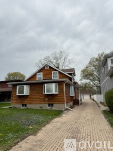 A wooden house with a brick pathway leading to it.