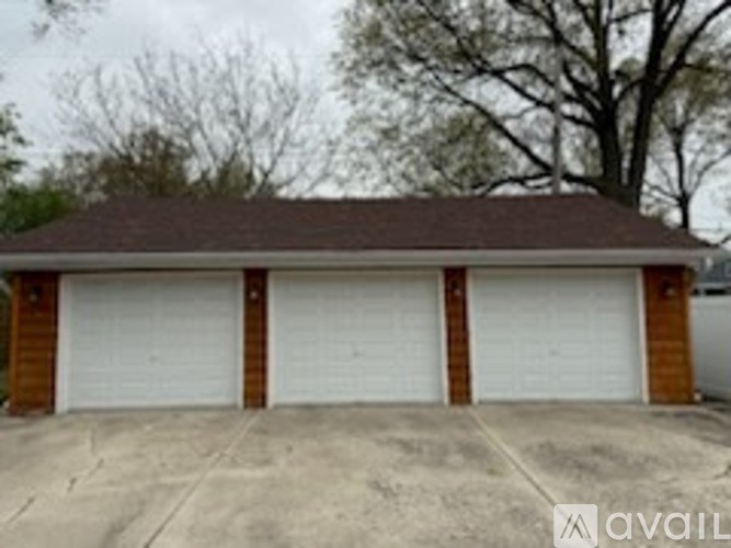 A two-car garage with a brown roof and white doors.