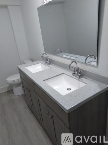 A bathroom with a sink, toilet and mirror.