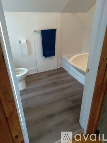 A bathroom with a toilet, sink, and a blue towel.