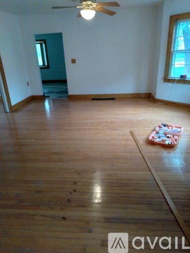 A room with wooden flooring and a ceiling fan.