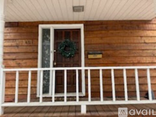 A wooden house with a door and a wreath on it.
