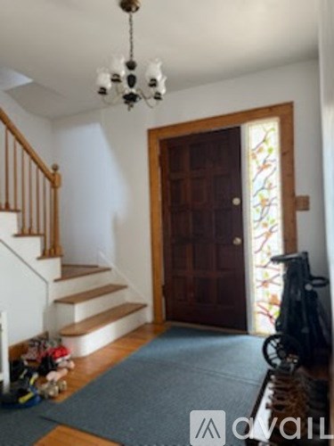 A hallway with a wooden door and a staircase.