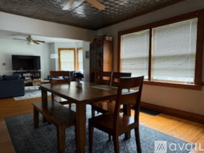 A dining room with a wooden table and chairs.