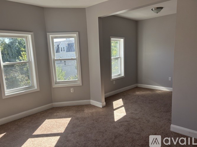 A room with two windows and carpeted floor.