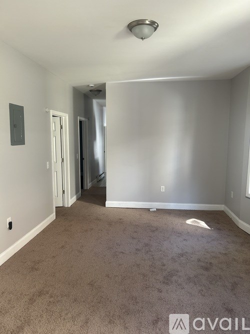 A room with carpeted floor and a doorway leading to another room.