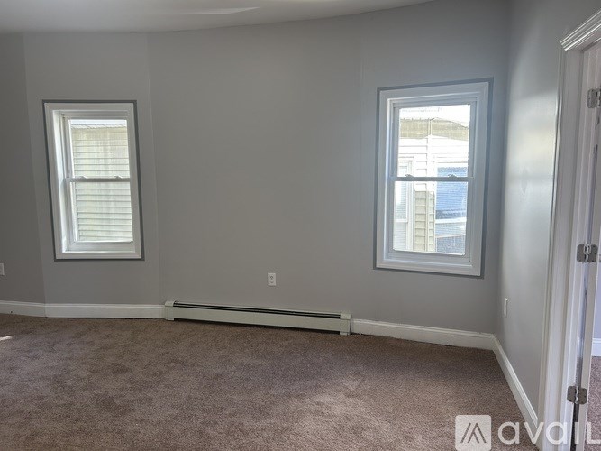 A room with two windows and a carpeted floor.