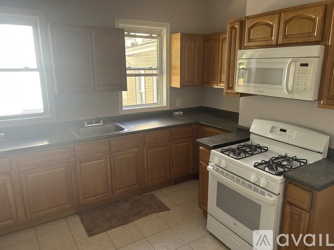 A kitchen with wooden cabinets and a white stove.