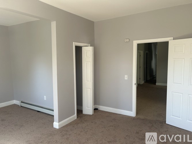 A room with two white doors and a carpeted floor.