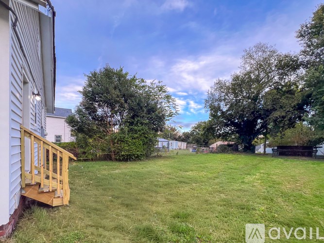 A backyard with a wooden deck and a grassy area.