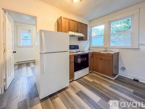 A kitchen with a white refrigerator and wooden cabinets.