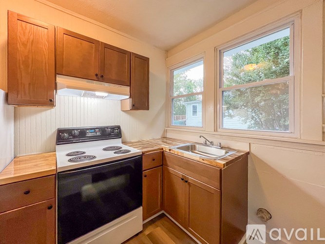 A kitchen with wooden cabinets and a black stove top oven.