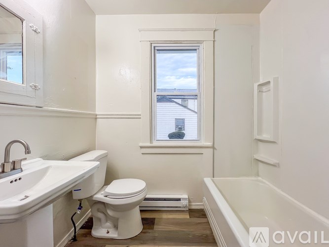 A bathroom with a toilet, sink, and bathtub.