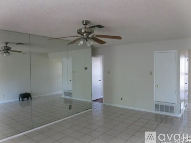 A spacious room with a ceiling fan and a glass wall.