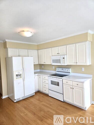 A kitchen with white appliances and cabinets.