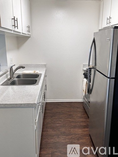 A kitchen with a sink and a refrigerator.
