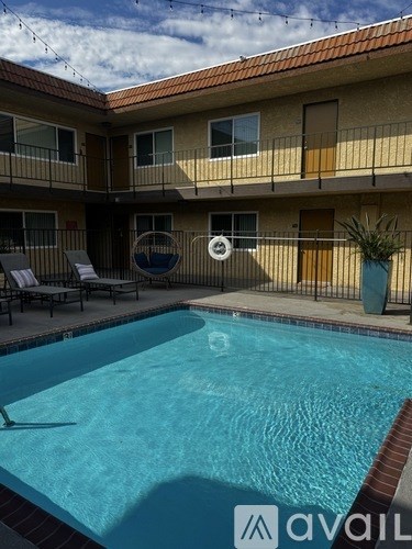 A pool in front of a building with a sign that says "avail".