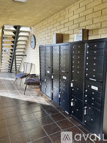 A row of black mailboxes are lined up against a brick wall.