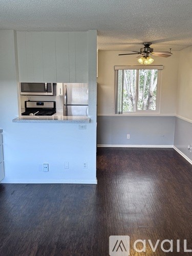 A room with a window and a fan on the ceiling.