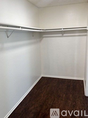 A room with a white wall and a wooden floor.