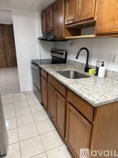 A kitchen with wooden cabinets and a granite countertop.