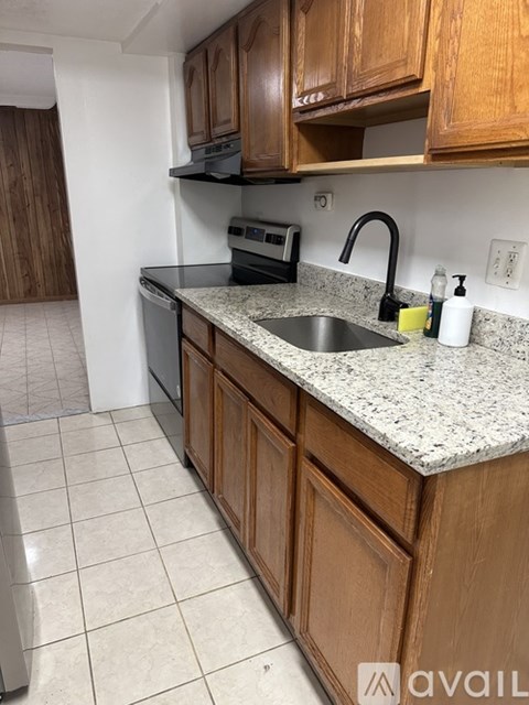 A kitchen with wooden cabinets and a granite countertop.