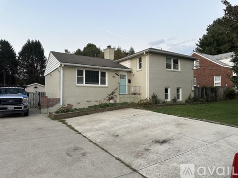 A house with a grey front and a blue door is for sale.