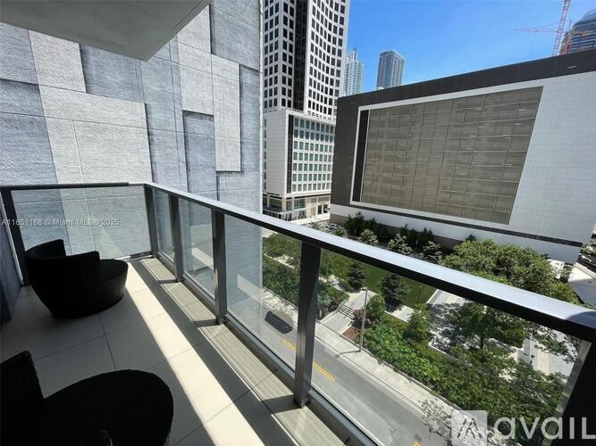 A balcony with a table and chairs overlooking a city street.
