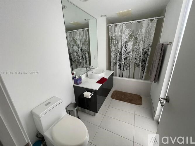 A bathroom with a toilet, sink, and a mirror.