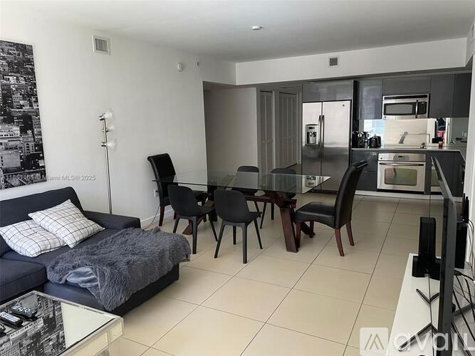 A modern living room with a blue couch and a glass table.