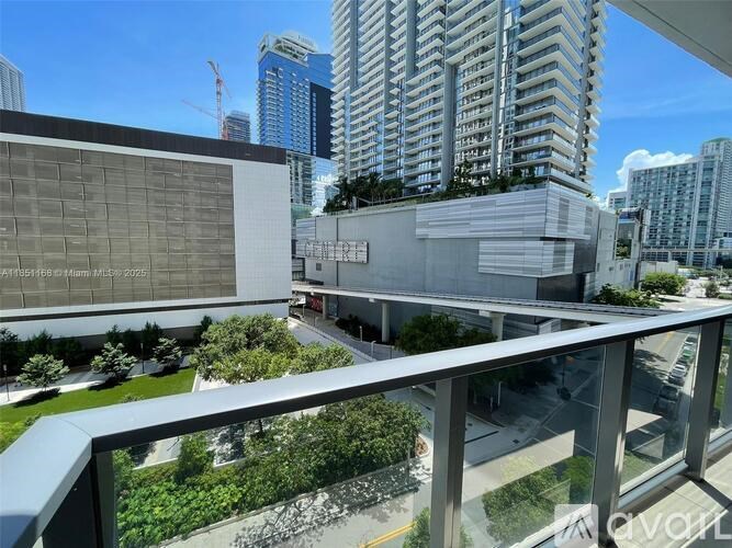 A view from a balcony overlooking a cityscape with modern buildings.