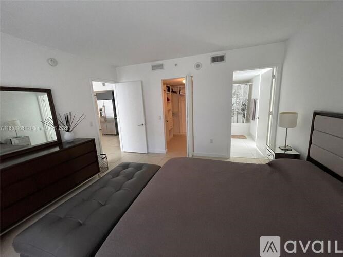 A bedroom with a large bed and a mirror on the wall.