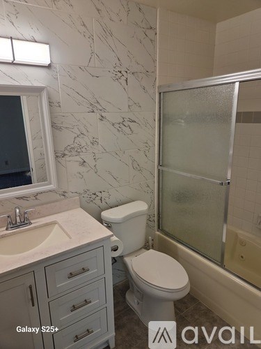 A bathroom with a toilet, sink, and shower.