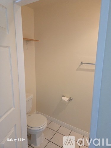 A white toilet in a small bathroom with a white door.