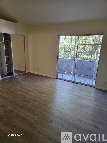 A spacious room with a Galaxy S25+ and Avail logo on the floor.