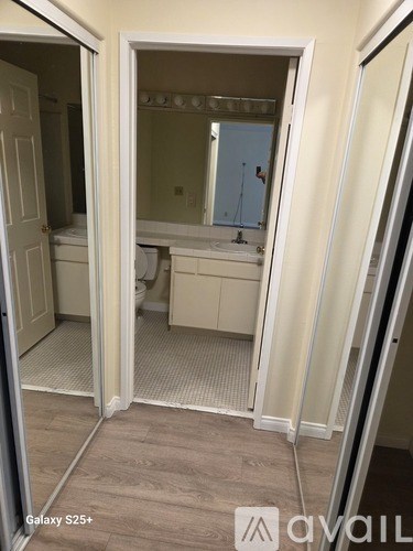 A bathroom with a toilet, sink, and mirror.