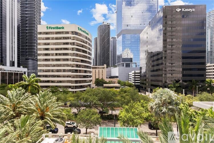 A cityscape with palm trees and buildings including one with a FirstBank sign.