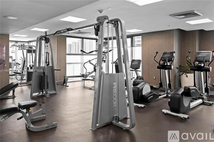 A gym with a variety of exercise equipment including treadmills, stationary bikes, and weight machines.