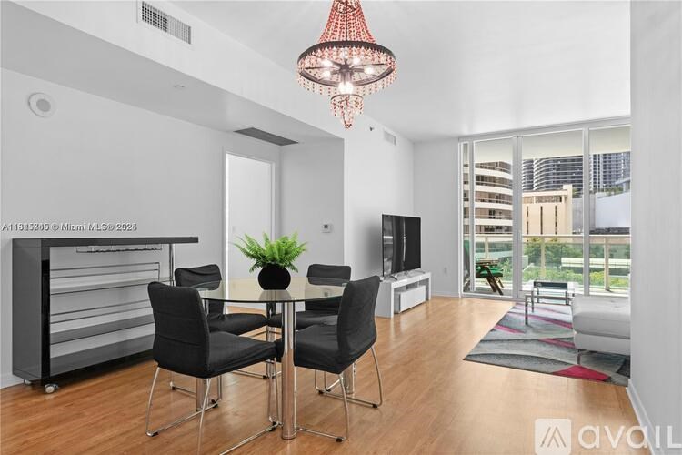 A modern dining room with a glass table and chairs.