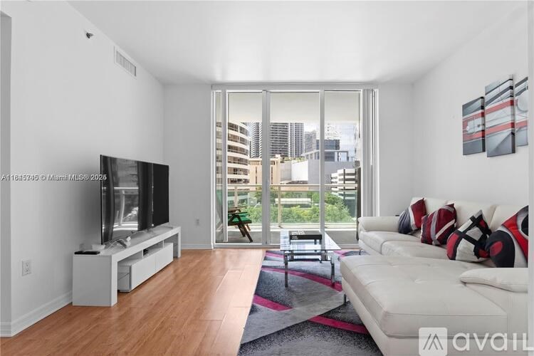 A living room with a white couch and a television.